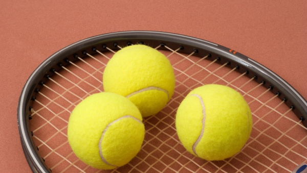 Raquette de tennis avec trois balles de tennis